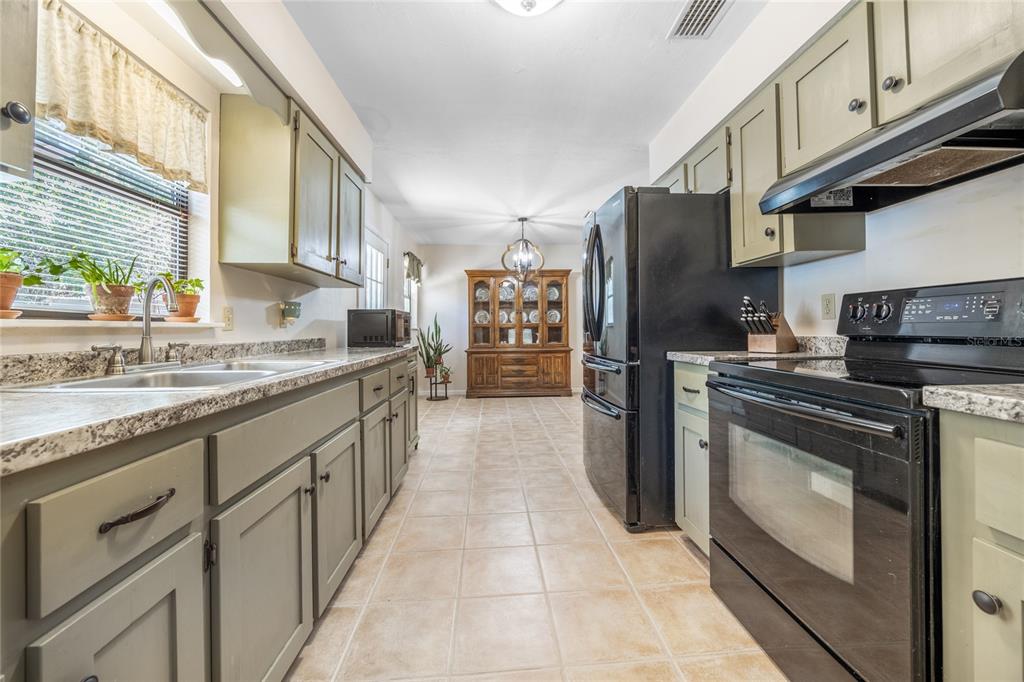 545 Southwest 257 Terrace Newberry, FL 32669 - Photo 13 of 46 a large kitchen with stainless steel appliances granite countertop a stove and a refrigerator