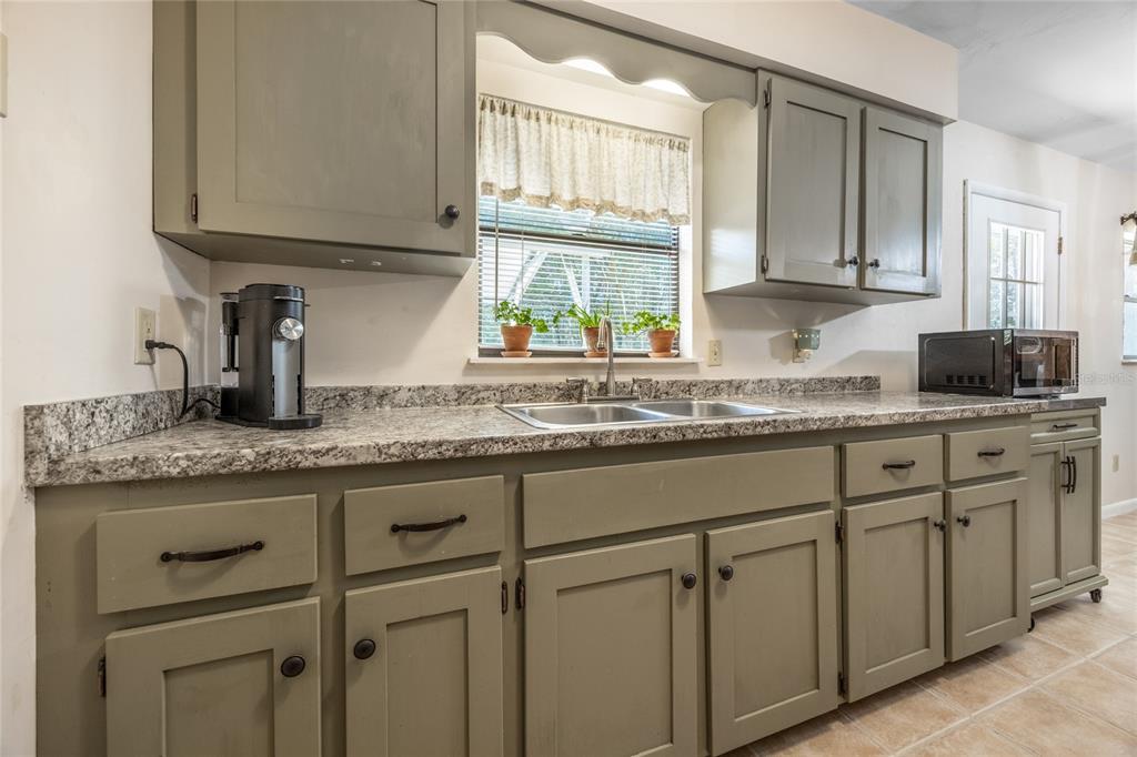 545 Southwest 257 Terrace Newberry, FL 32669 - Photo 14 of 46 a kitchen with granite countertop white cabinets and white appliances