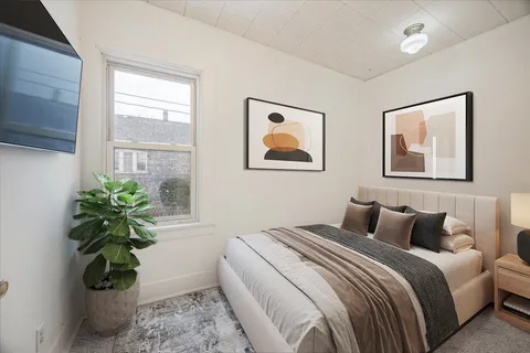 a bedroom with bed and three windows