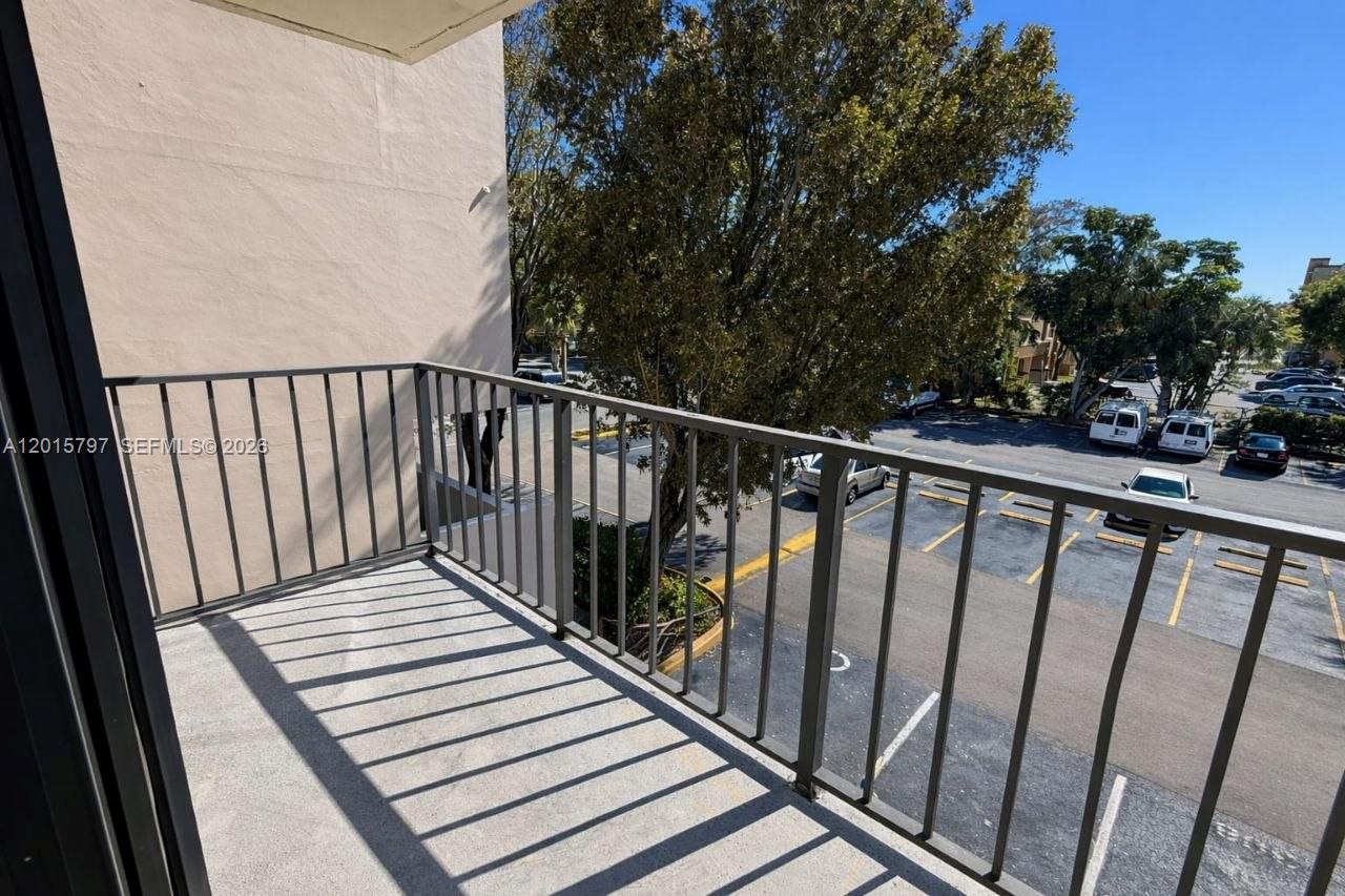 8002 Southwest 149th Avenue, Unit B310 Miami, FL 33193 - Photo 14 of 16 a view of balcony with wooden floor and fence
