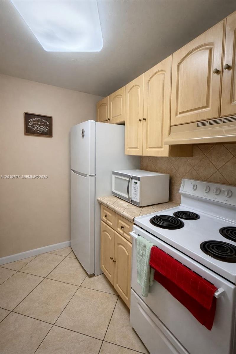 8002 Southwest 149th Avenue, Unit B310 Miami, FL 33193 - Photo 4 of 16 a kitchen with stainless steel appliances granite countertop a refrigerator and a stove