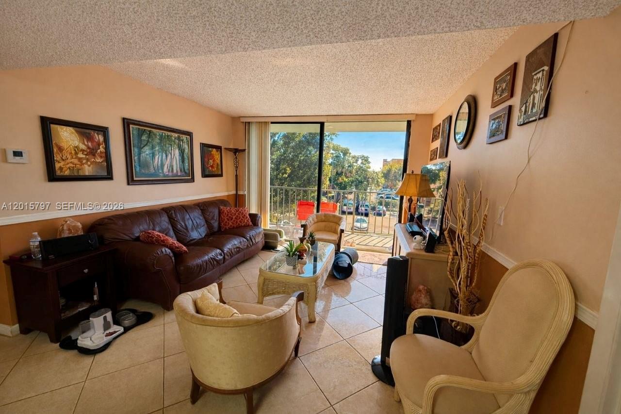 8002 Southwest 149th Avenue, Unit B310 Miami, FL 33193 - Photo 9 of 16 a living room with furniture and a flat screen tv