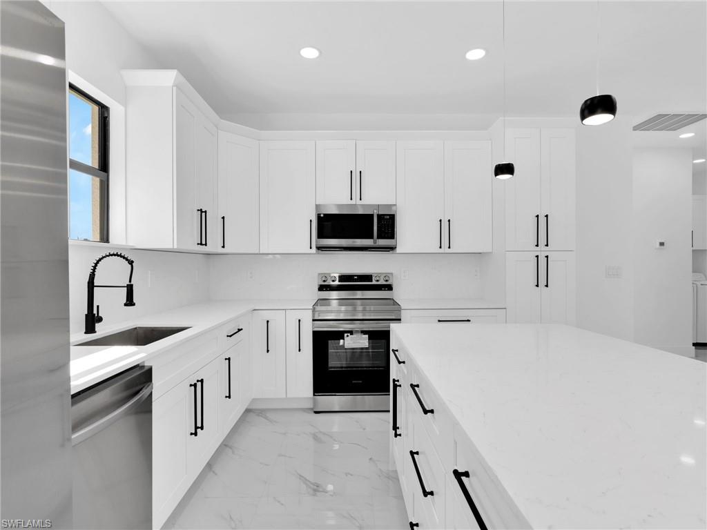 3419 8th Street Southwest Lehigh Acres, FL 33976 - Photo 12 of 29 a kitchen with granite countertop a sink stove and refrigerator