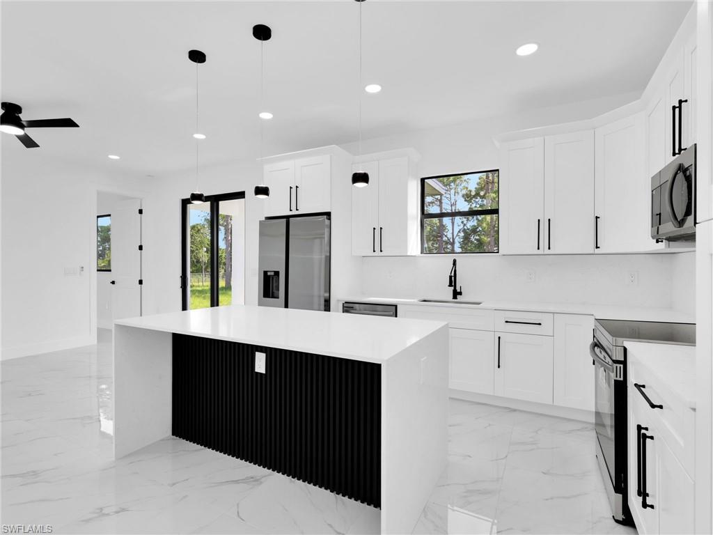 3419 8th Street Southwest Lehigh Acres, FL 33976 - Photo 10 of 29 a kitchen with a sink window and cabinets