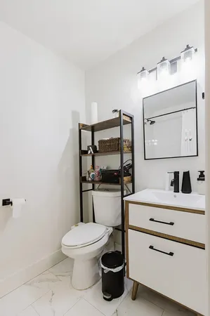 a bathroom with a toilet a sink and mirror