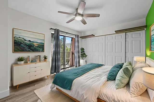 a bedroom with a bed and a chandelier fan
