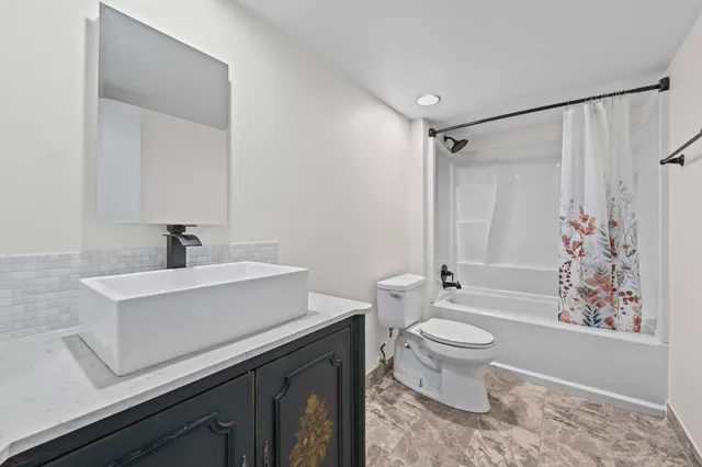 a bathroom with a sink toilet a mirror and shower