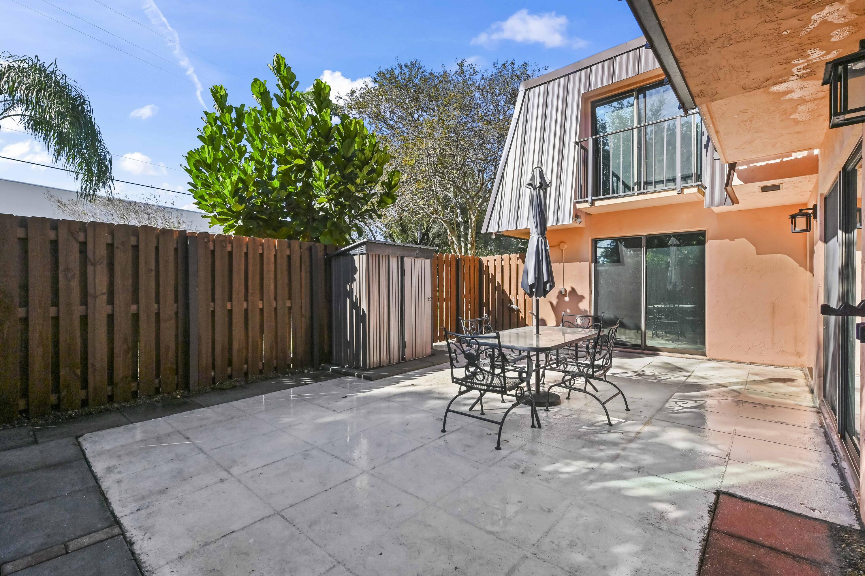 5708 Southeast Windsong Lane Stuart, FL 34997 - Photo 5 of 41 a patio with table and chairs and potted plants