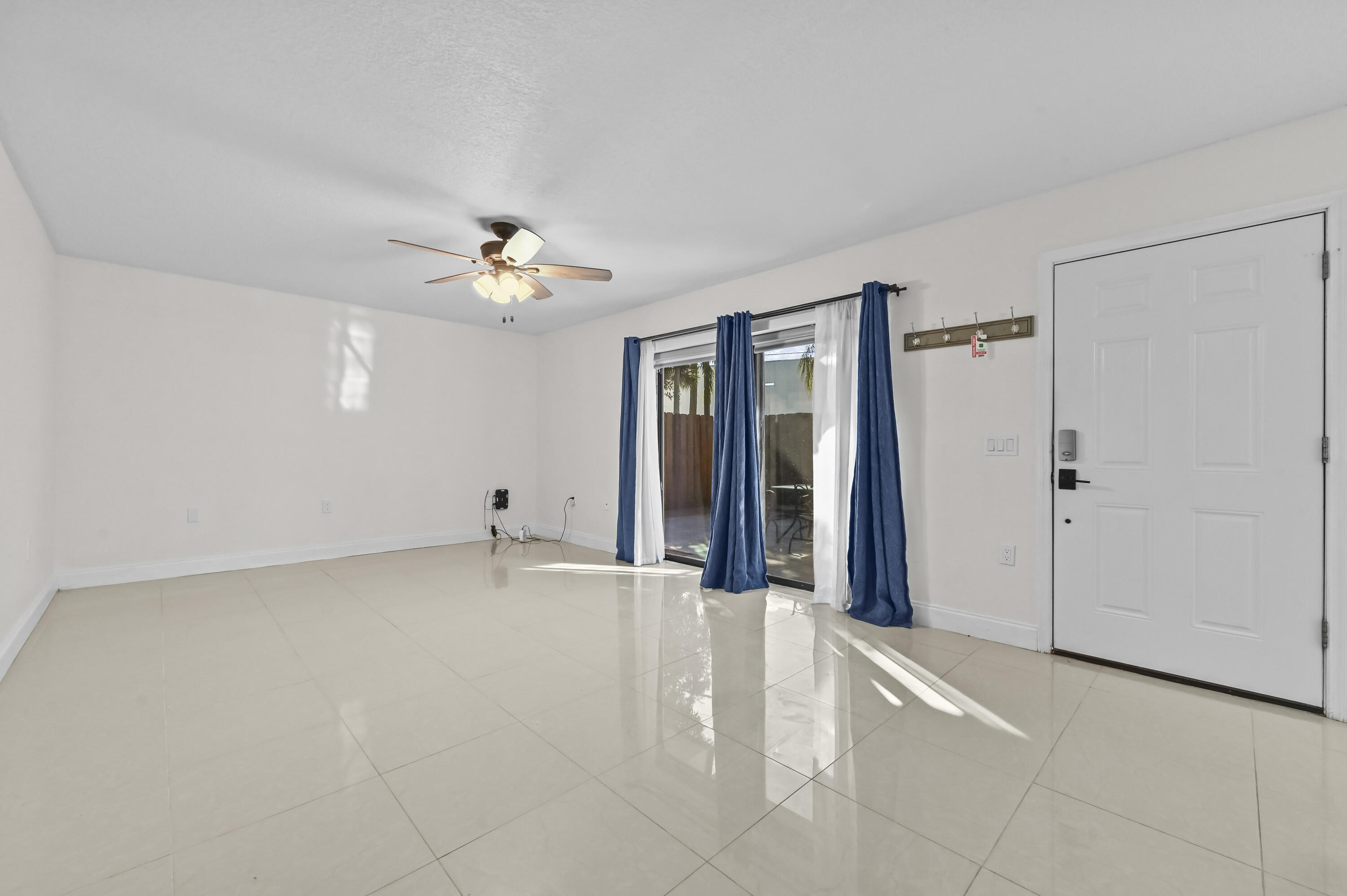 5708 Southeast Windsong Lane Stuart, FL 34997 - Photo 9 of 41 a view of an empty room with a ceiling fan