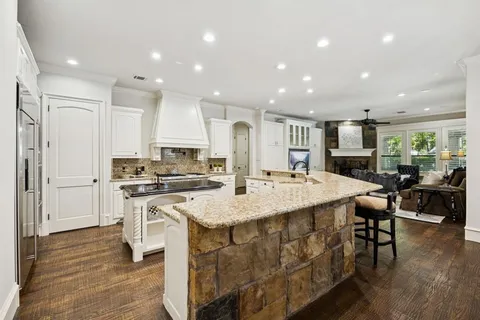a large kitchen with kitchen island a sink a stove a dining table and chairs