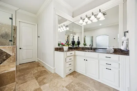 a spacious bathroom with a granite countertop sink a mirror and a shower