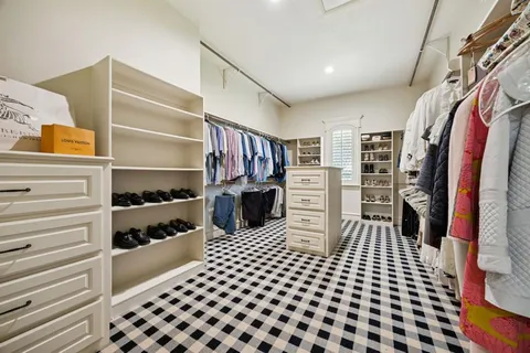 a view of walk in closet with clothes and shoes