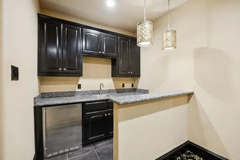 a kitchen with granite countertop stainless steel appliances a sink stove top oven and cabinets