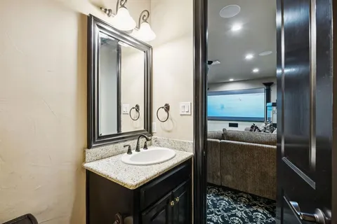 a bathroom with a granite countertop sink a mirror and a shower