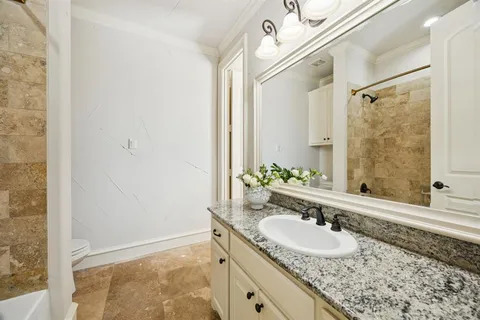 a bathroom with a granite countertop sink a mirror and a shower