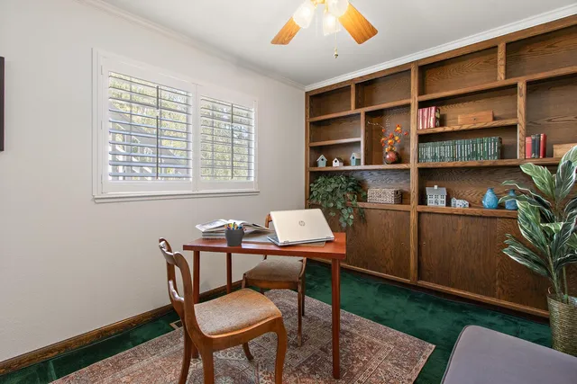 a view of a workspace with furniture and a window