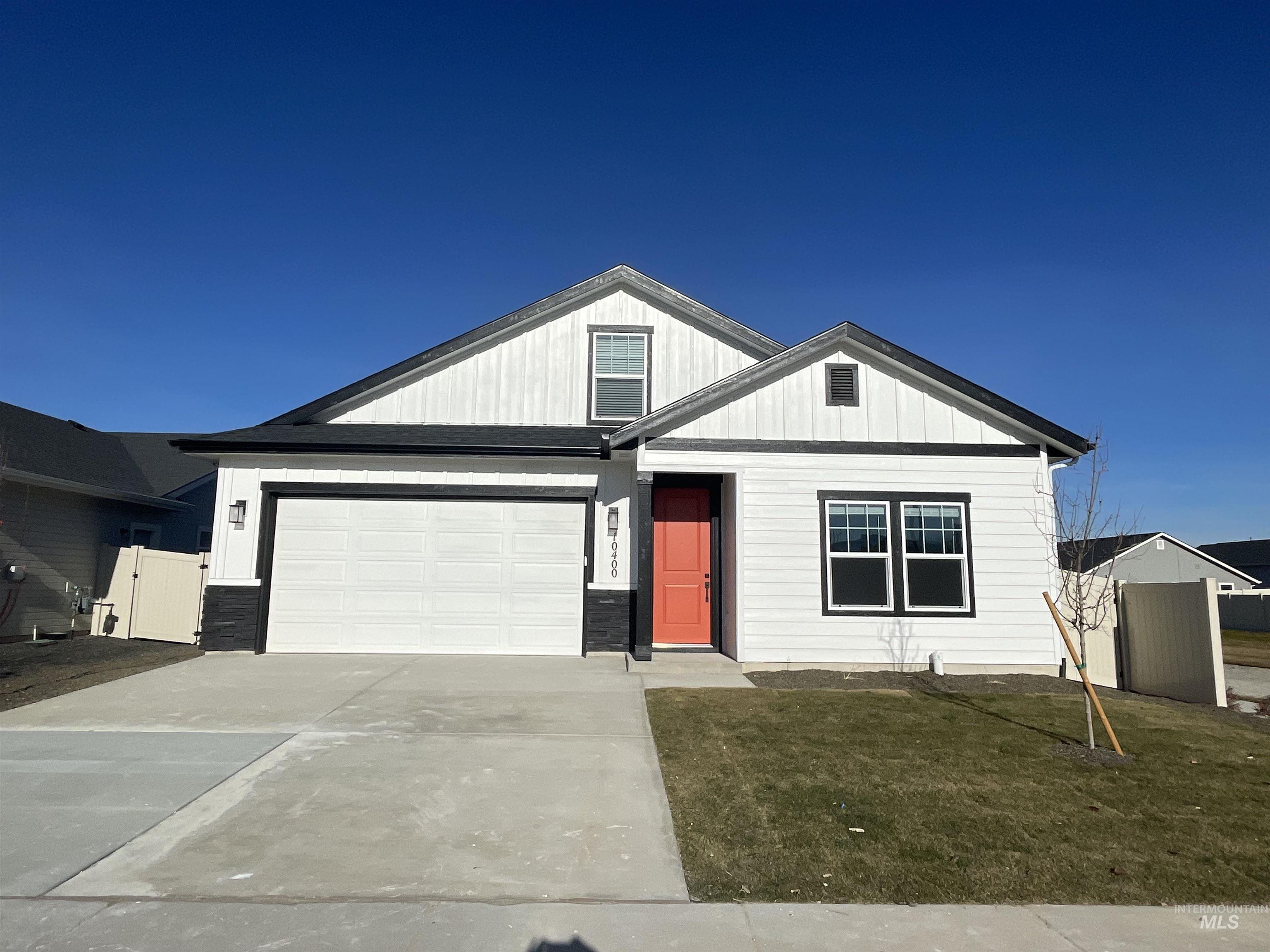 View of front facade featuring driveway, a front yard, and a garage