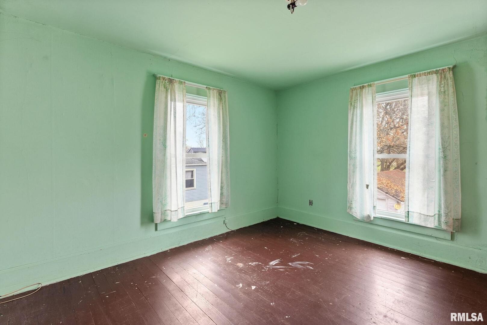 315 West Locust Street Cambridge, IL 61238 - Photo 13 of 27 an empty room with wooden floor and windows