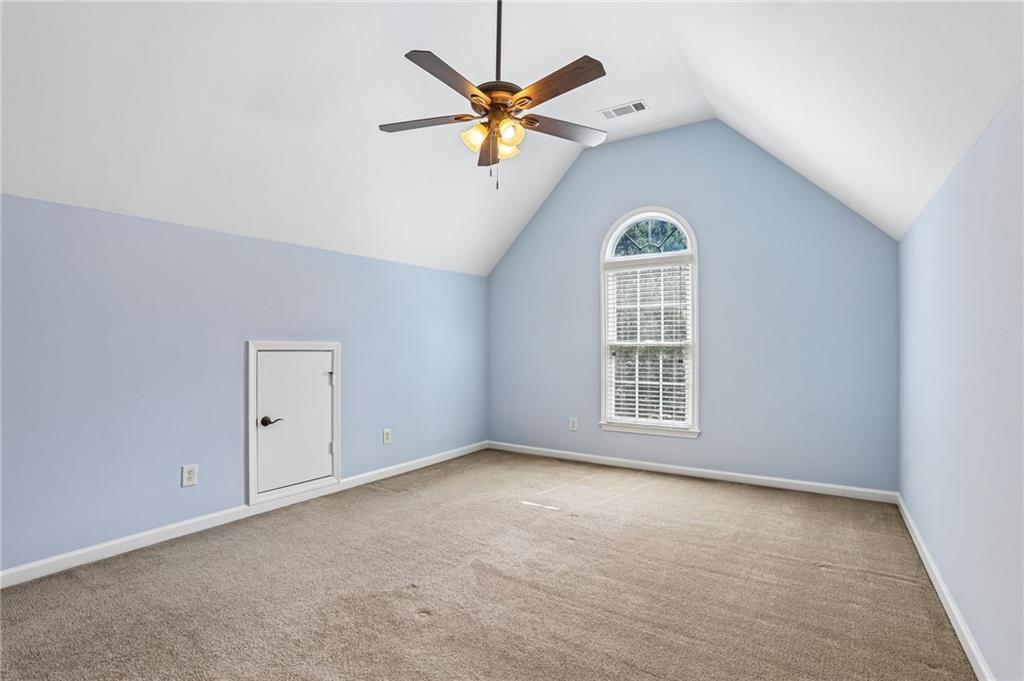 810 Freedom Way Cumming, GA 30040 - Photo 38 of 61 an empty room with a window and a ceiling fan