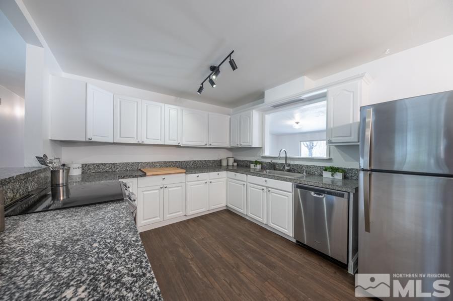 1325 Kings Court Reno, NV 89503 - Photo 4 of 14 a kitchen with stainless steel appliances granite countertop a refrigerator a sink dishwasher a stove with wooden cabinets and floor