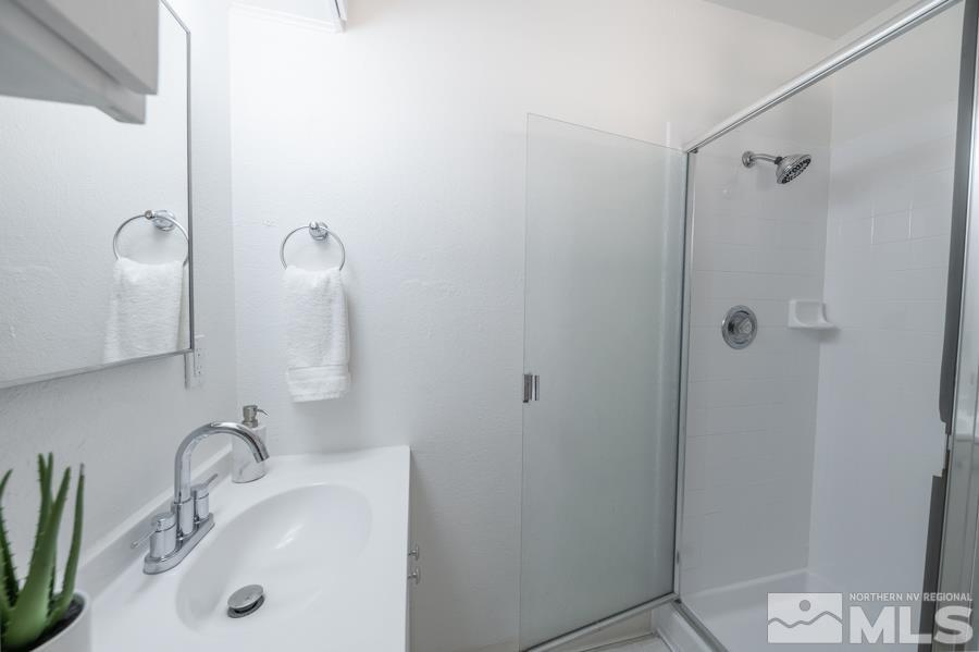 1325 Kings Court Reno, NV 89503 - Photo 9 of 14 a bathroom with a sink a mirror and shower