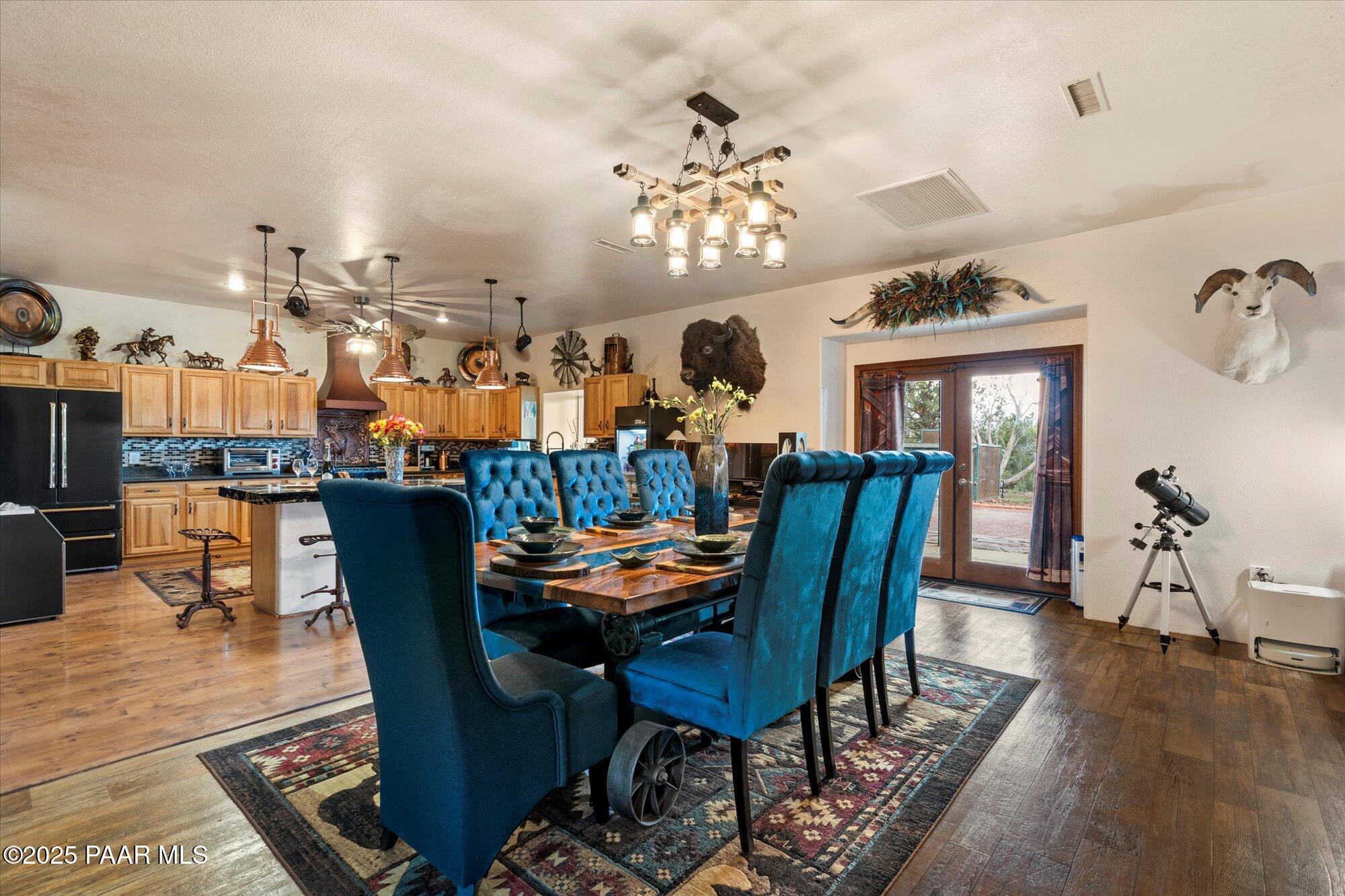33425 Cowboy Clint Road Seligman, AZ 86337 - Photo 20 of 79 a dining room with furniture a chandelier and wooden floor