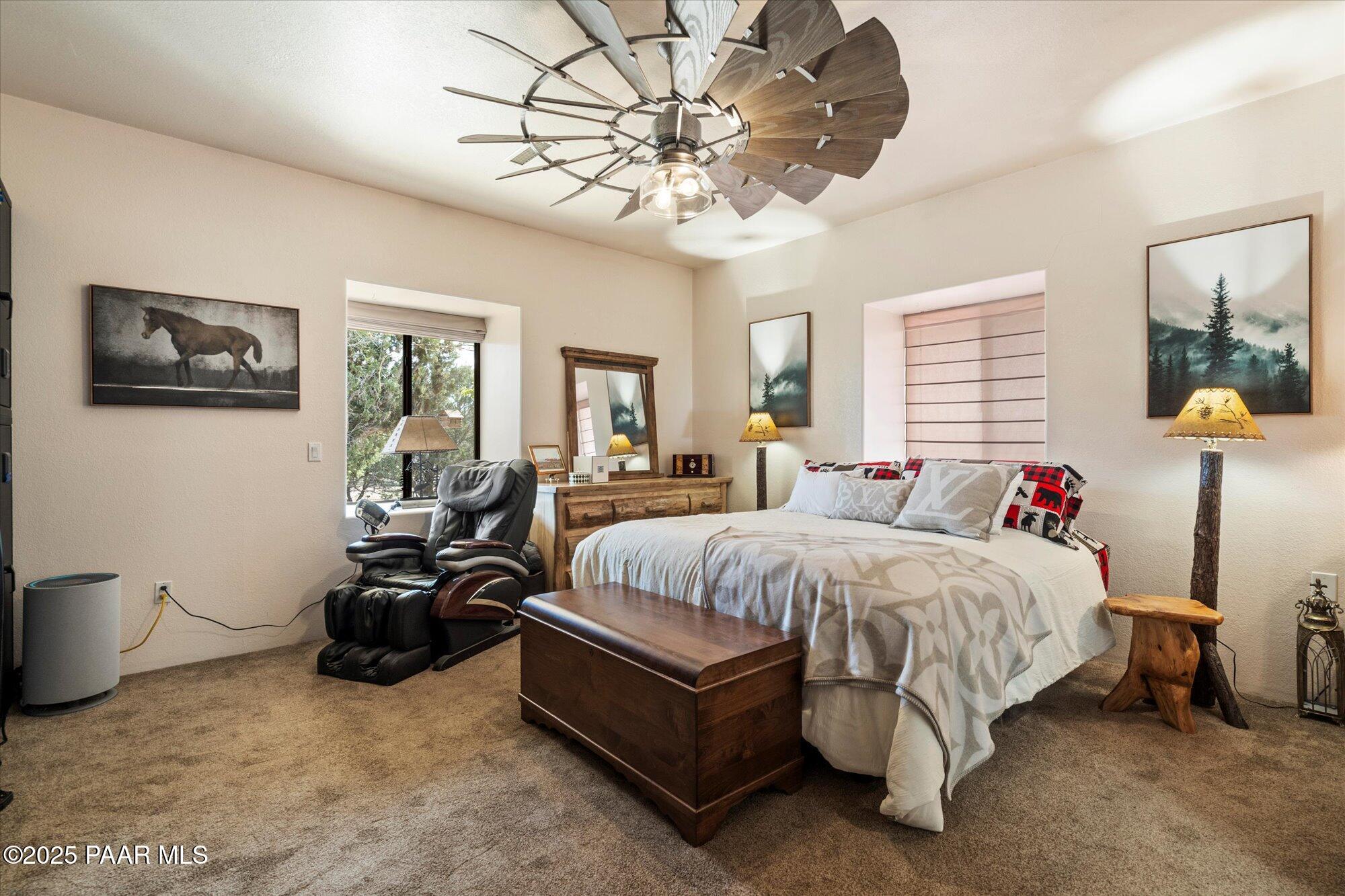 33425 Cowboy Clint Road Seligman, AZ 86337 - Photo 27 of 79 a spacious bedroom with a bed couch chandelier and window