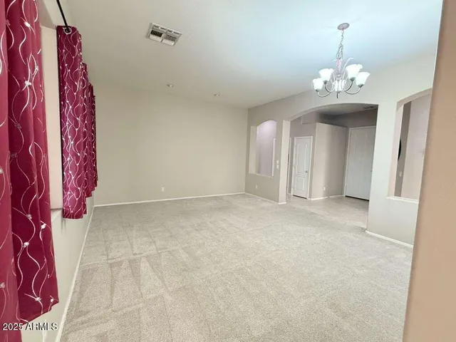 a view of a livingroom with an entryway and wooden floor