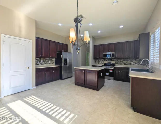 a kitchen with stainless steel appliances granite countertop a sink refrigerator and cabinets