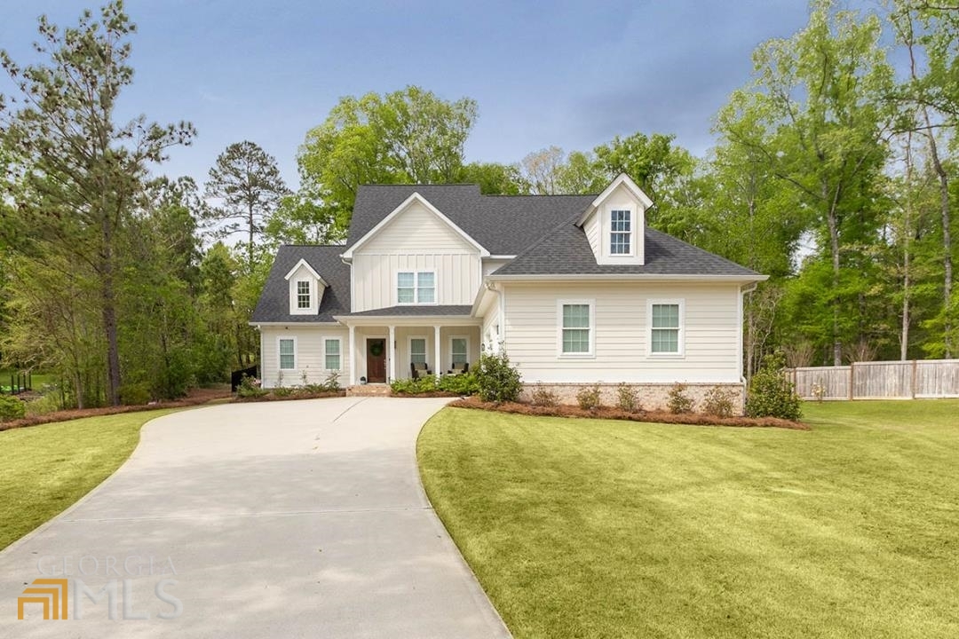 a front view of a house with a garden and trees