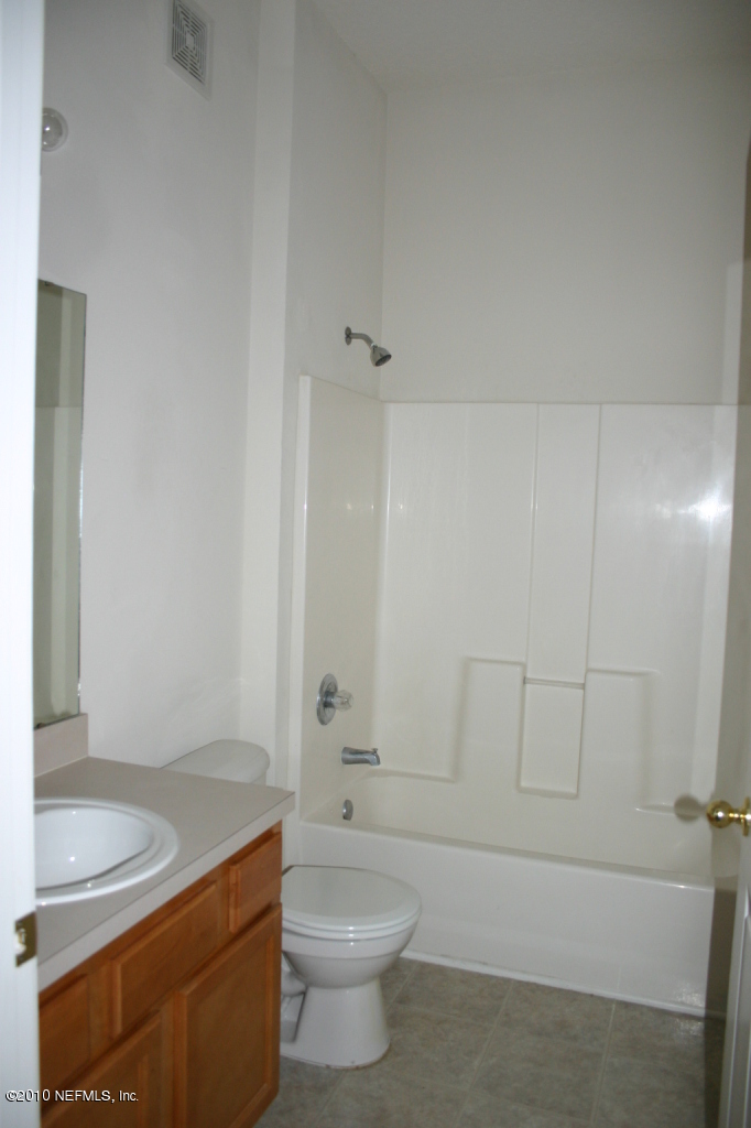 7920 Merrill Road, Unit 1102 Jacksonville, FL 32277 - Photo 8 of 20 a bathroom with a granite countertop sink a toilet and bathtub