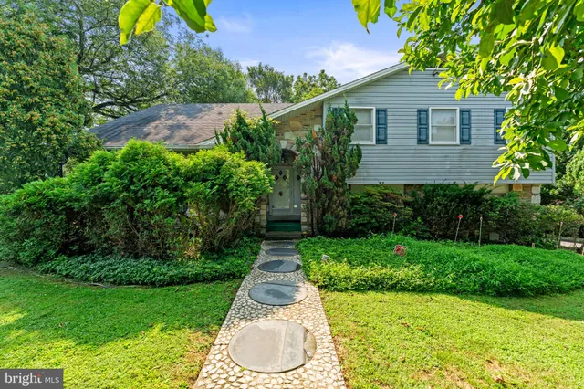 a front view of a house with a yard and green space