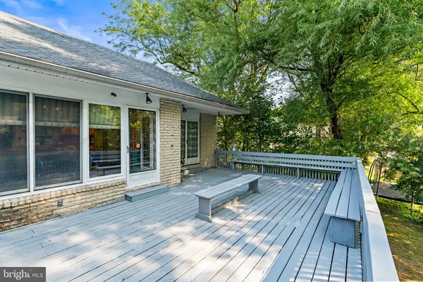 a view of house with wooden deck and seating space