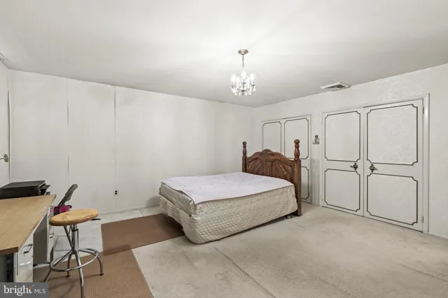 a spacious bedroom with a bed and a chandelier