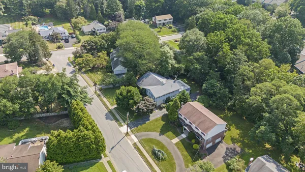 an aerial view of residential house with outdoor space and trees all around