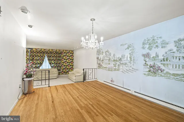 a view of a livingroom with wooden floor and a chandelier