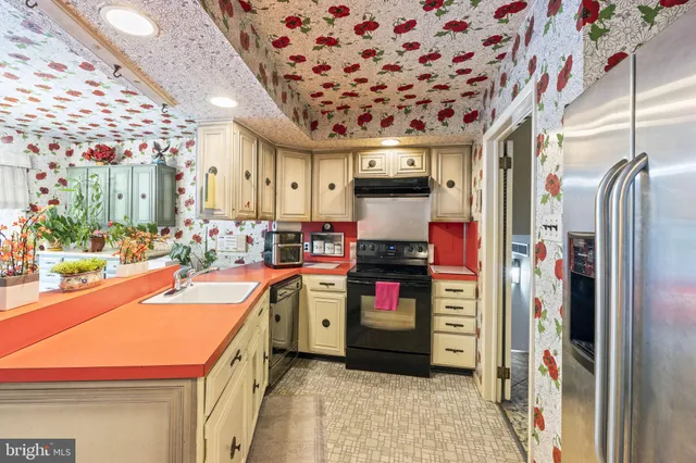 a view of a kitchen with a sink and a refrigerator