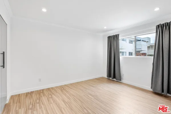 a view of a big room with wooden floor and windows