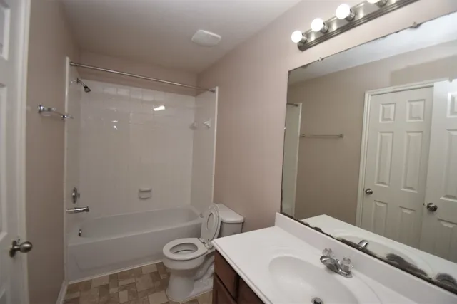 a bathroom with a sink a toilet a mirror and shower
