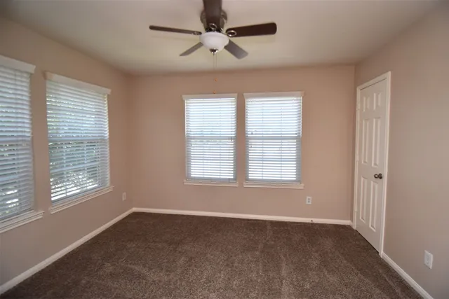 a big room with windows and chandelier fan