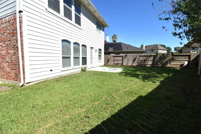a view of a yard in front of a house with large tree
