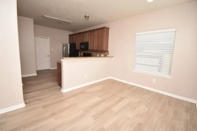a view of a room with wooden floor and a window