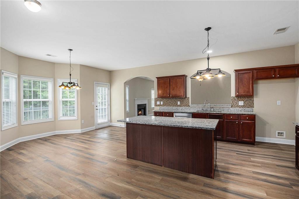 6054 Locklear Way Douglasville, GA 30134 - Photo 12 of 36 a kitchen with stainless steel appliances granite countertop wooden floors and white cabinets
