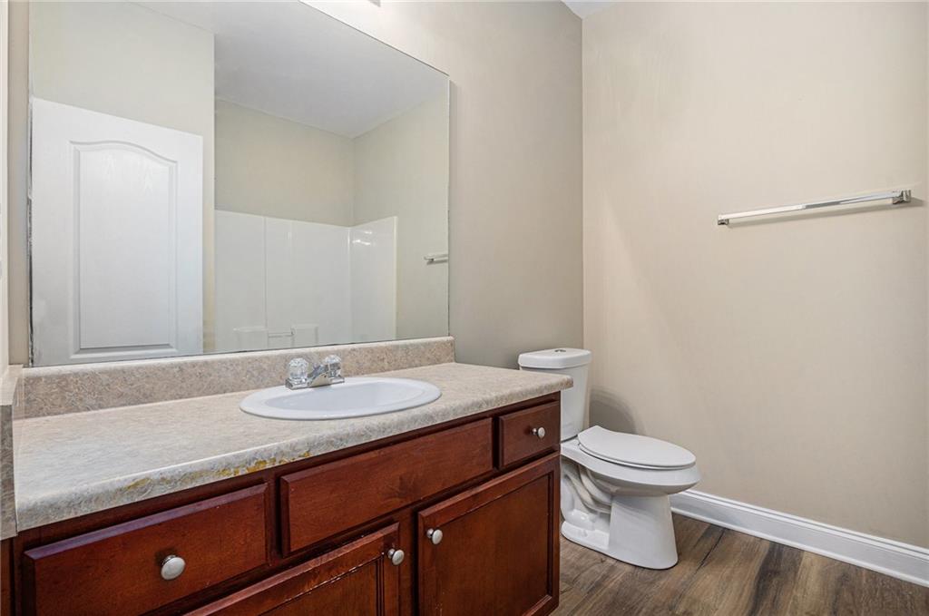 6054 Locklear Way Douglasville, GA 30134 - Photo 16 of 36 a bathroom with a granite countertop sink a toilet and a mirror