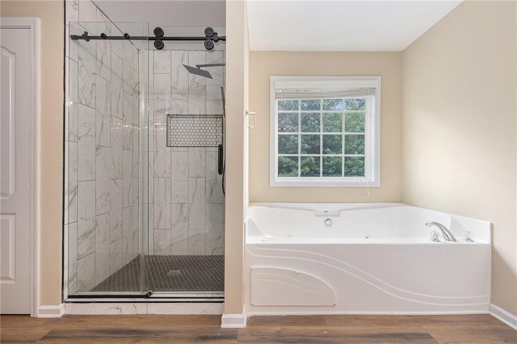 6054 Locklear Way Douglasville, GA 30134 - Photo 22 of 36 a bathroom with a bathtub and a shower