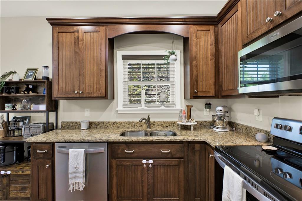 923 County Line Road Resaca, GA 30735 - Photo 20 of 49 a kitchen with stainless steel appliances granite countertop a sink stove and cabinets