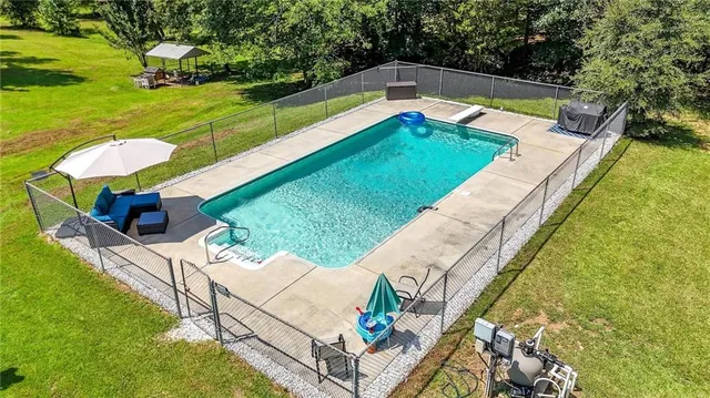 a view of a house with pool and a yard