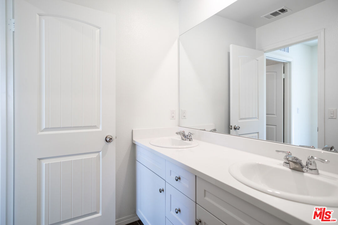 7935 Cold Creek Street Riverside, CA 92507 - Photo 27 of 45 a bathroom with a double vanity sink and a mirror