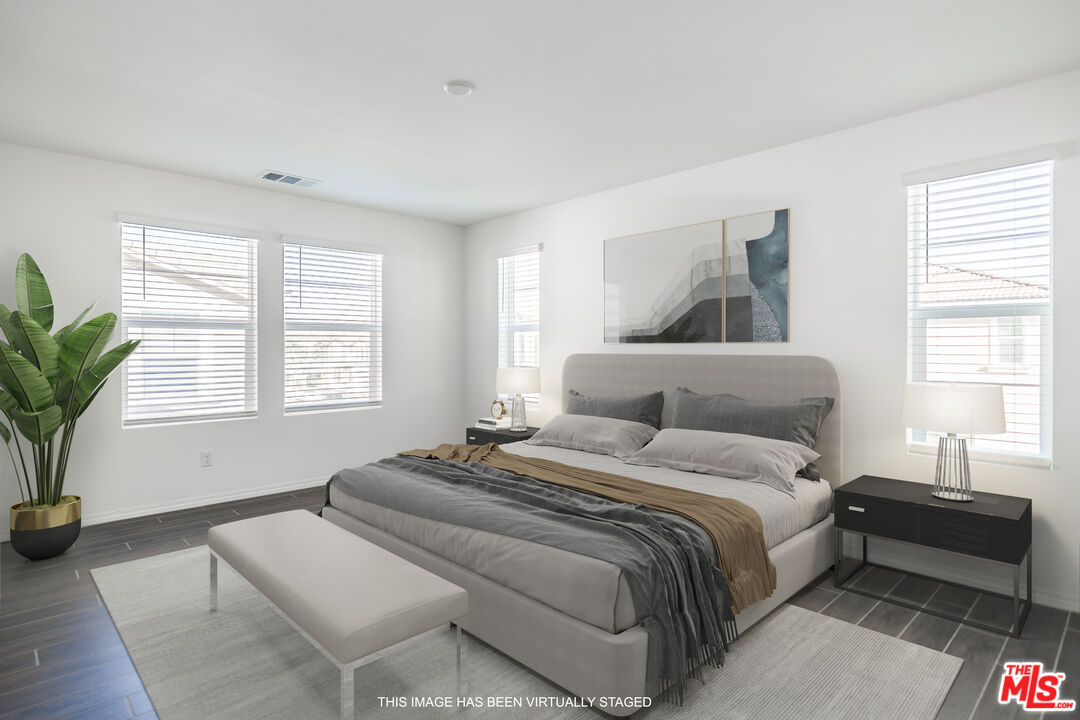 7935 Cold Creek Street Riverside, CA 92507 - Photo 31 of 45 a spacious bedroom with a bed and wooden floor