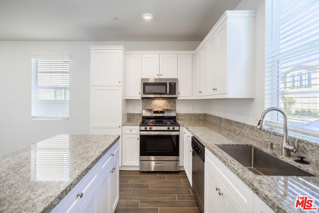 7935 Cold Creek Street Riverside, CA 92507 - Photo 5 of 45 a kitchen with granite countertop a stove sink and cabinets